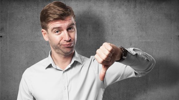 Mann schaut enttäuscht und zeigt Daumen nach unten